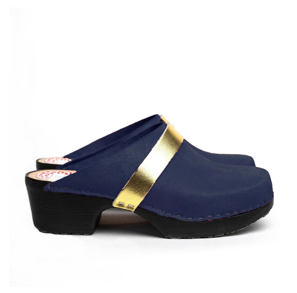 Navy blue clogs with a gold band on a white background